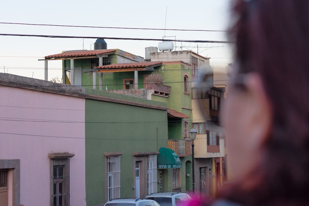 Una donna che guarda fuori da una finestra una fila di edifici