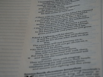 A close-up view of a page from a religious text, featuring printed passages and numbered verses. The text is aligned to the right side, with some sentences emphasized in bold.