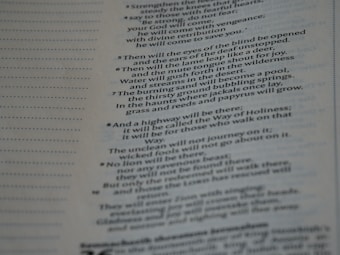 A close-up view of a page from a religious text, featuring printed passages and numbered verses. The text is aligned to the right side, with some sentences emphasized in bold.