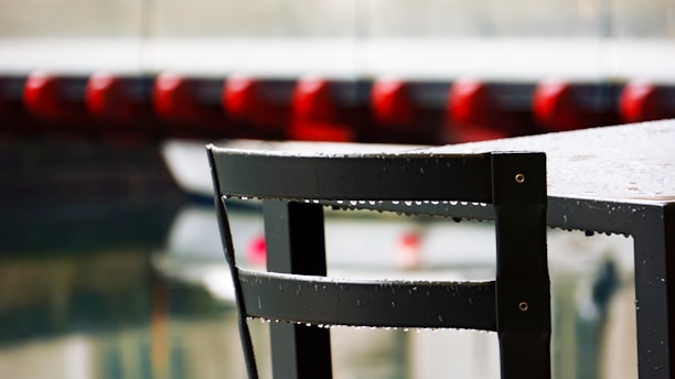 Close-up of the weatherproof metal patio table cover protecting a table from rain and leaves.