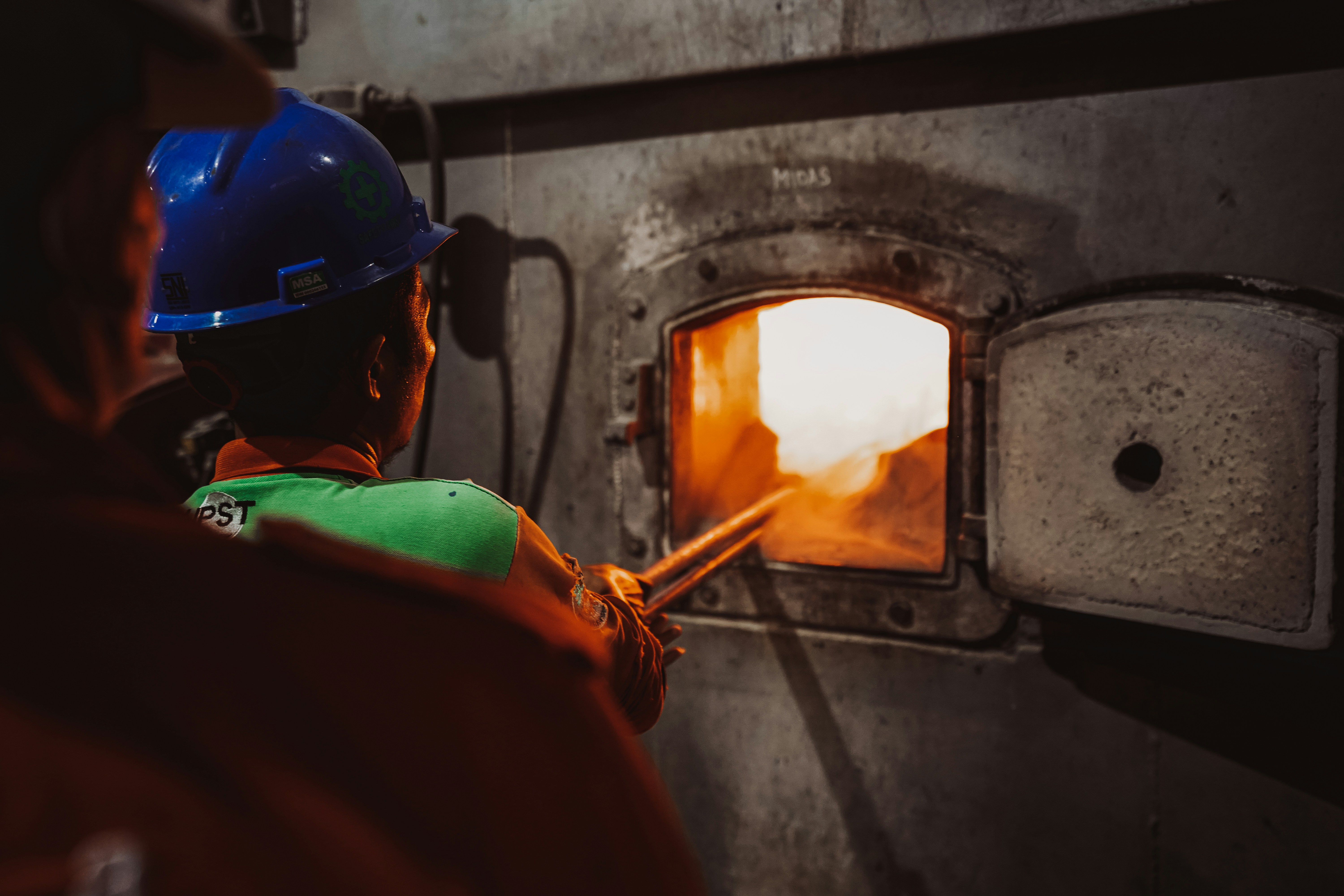 a man in a hard hat working on a furnace