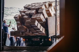 Image of a man checking a moving truck’s load with a clipboard on a bright day.