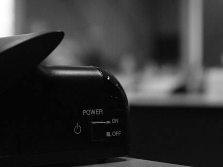 A close-up of a computer power button illuminated in green, indicating that the device is on.