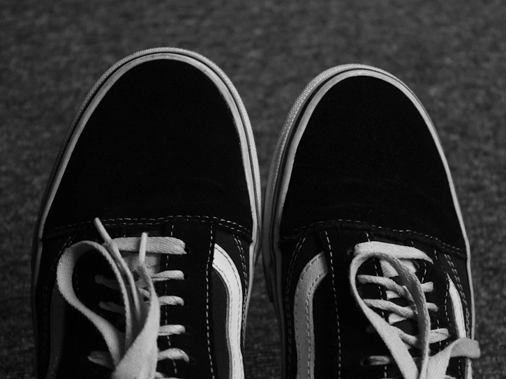 Close-up of a stylish pair of pre-loved sneakers with subtle wear, highlighting their authentic branded details.