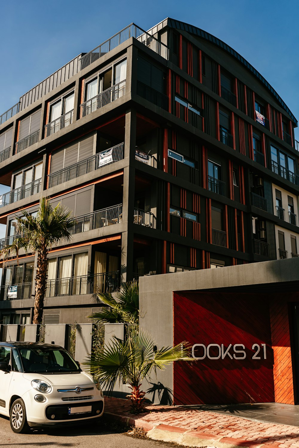 a white car parked in front of a tall building