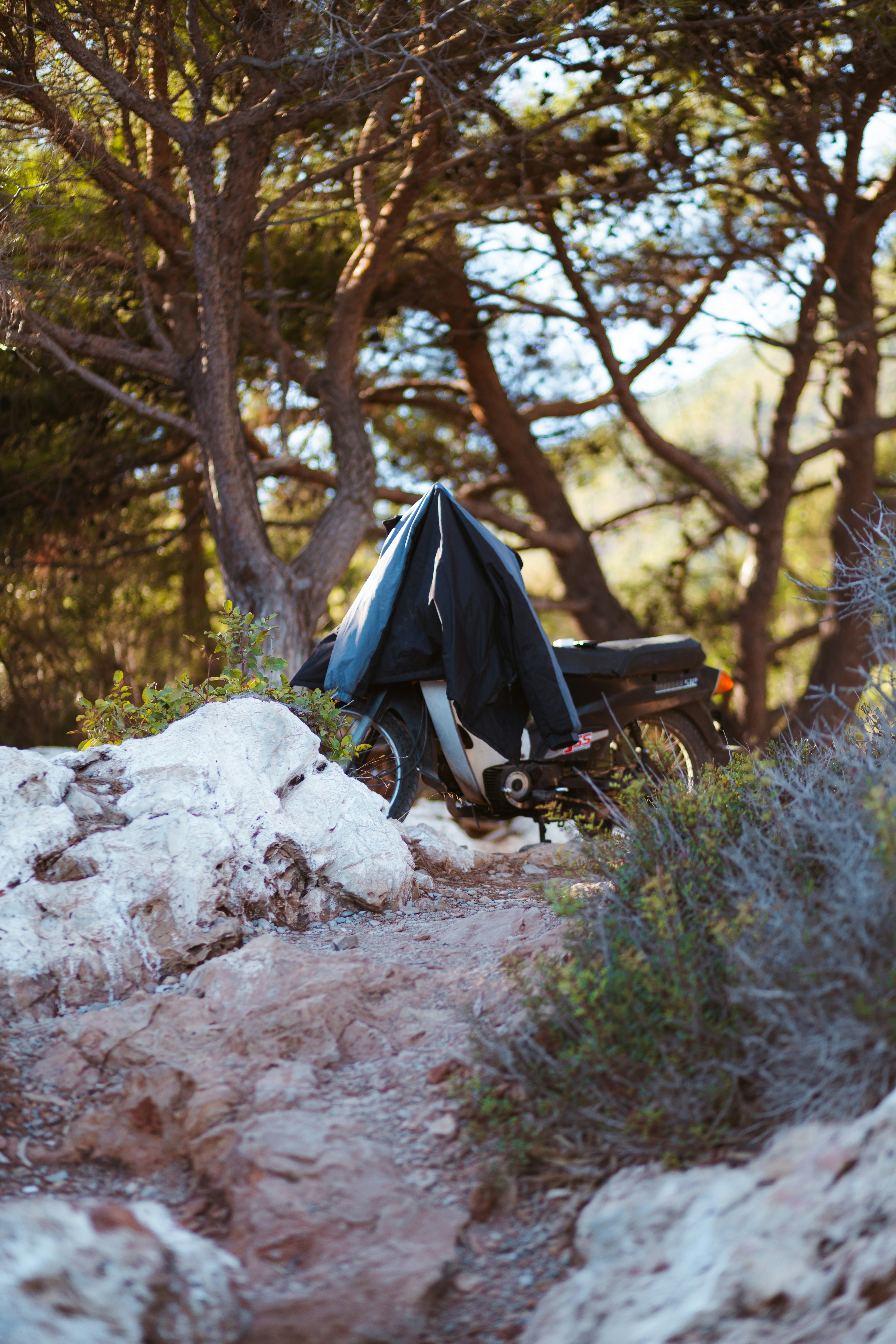 a motorcycle parked on top of a rocky hillside