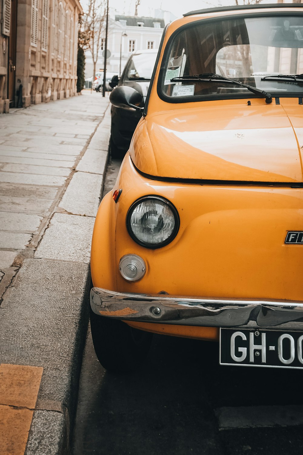 an orange car parked on the side of a street