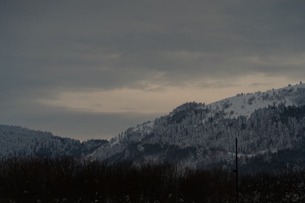 a mountain covered in snow under a cloudy sky