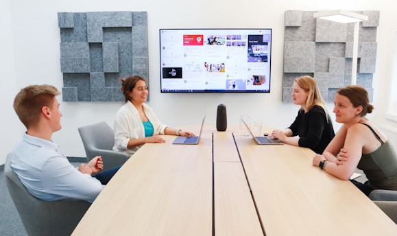 A team of marketing professionals collaborating online, discussing strategies on laptops and digital