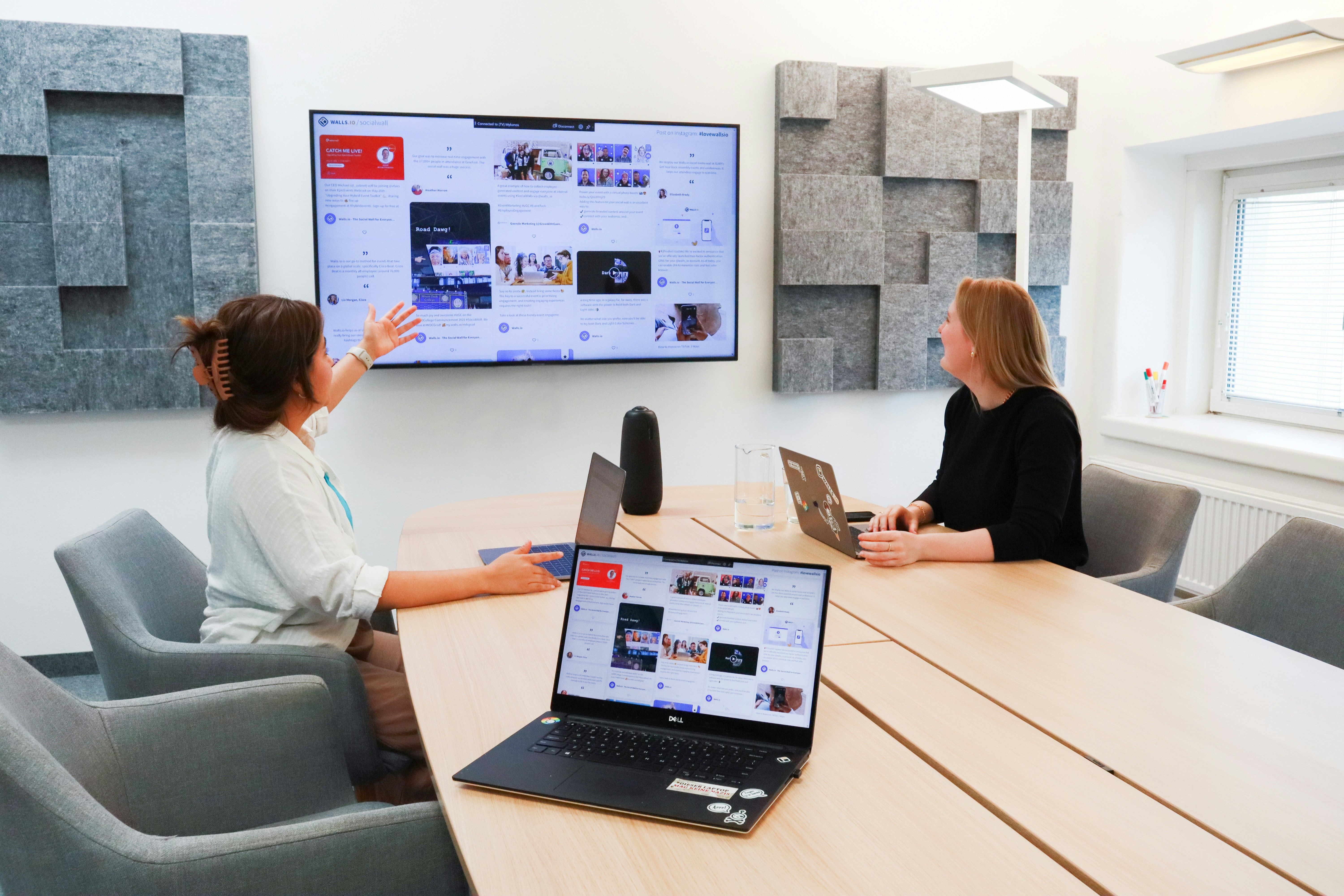 Two women having a meeting in an office with a screen on the wall