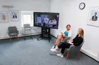 Candid moment of a team member discussing recruitment strategies with a client over video call.