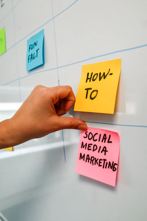 a hand is pointing to sticky notes on a bulletin board