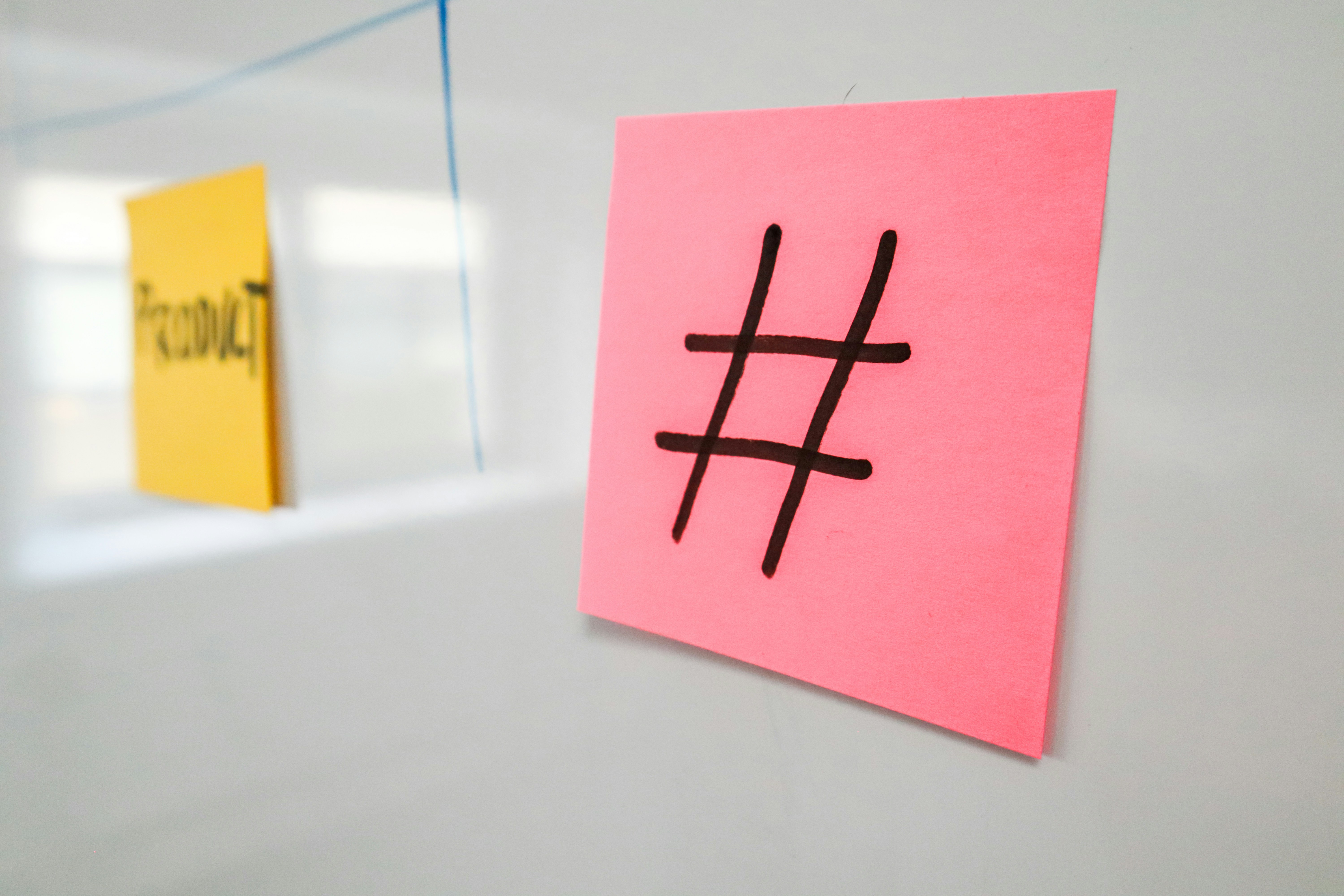 Sticky note on a white board with a hashtag on it