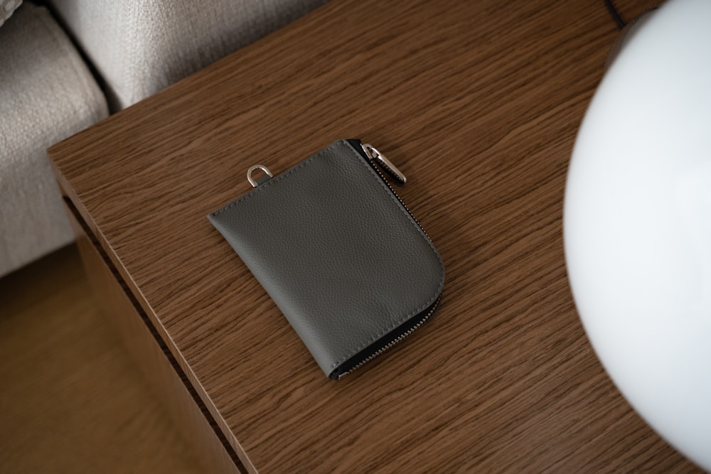 a small wallet sitting on top of a wooden table