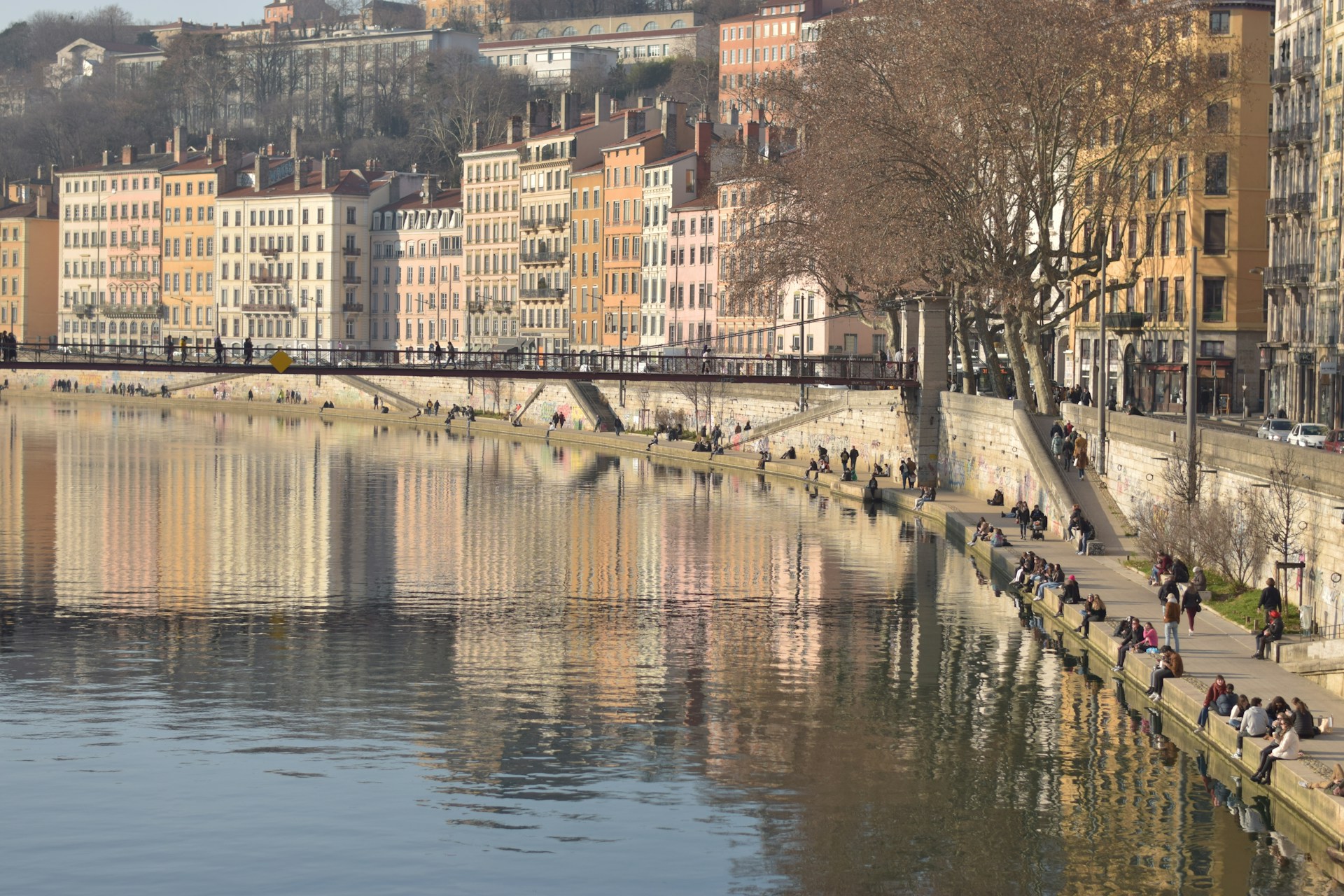 a group of people sitting on the side of a river