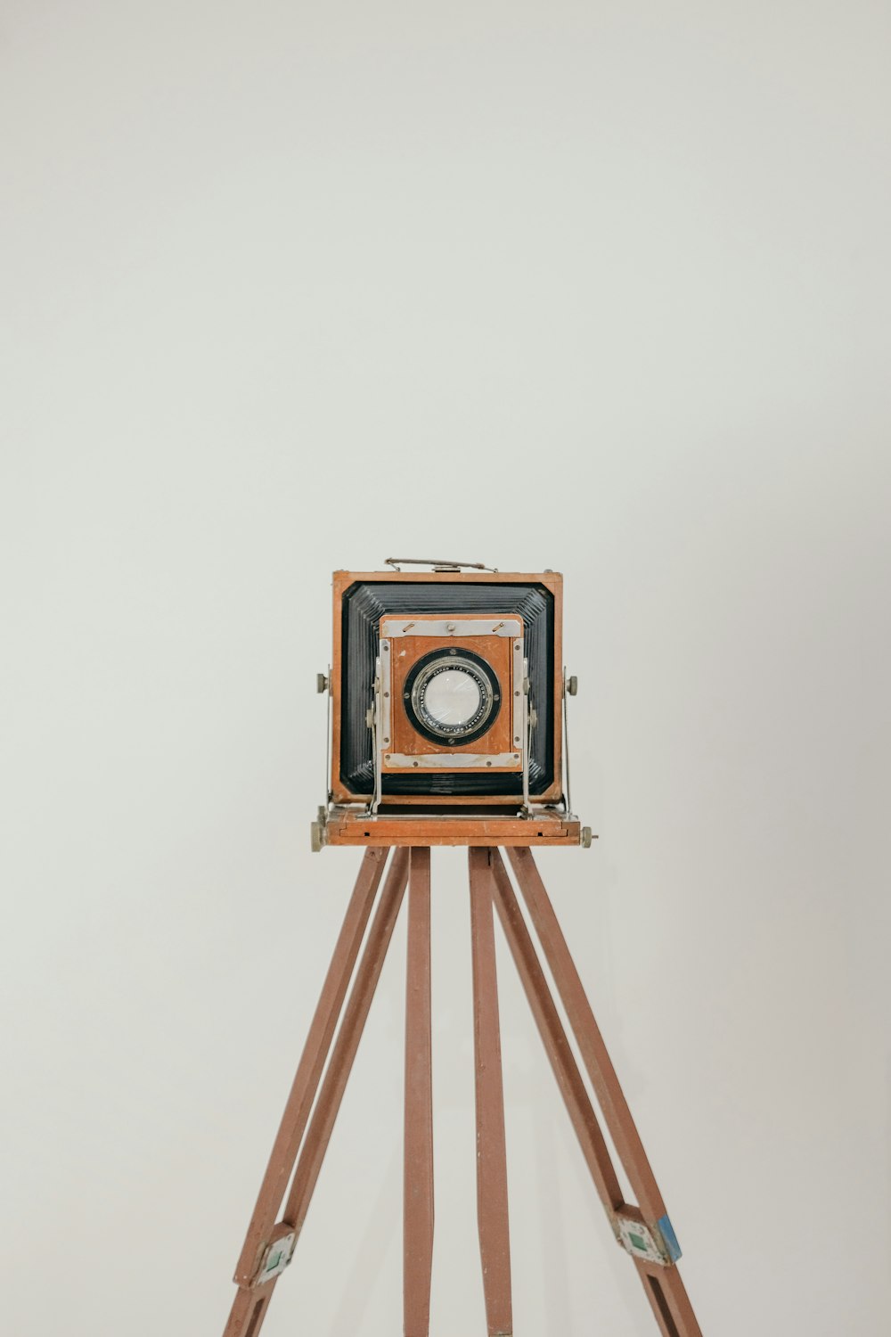 a wooden tripod with a camera on top of it