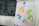 A flip chart with various colored sticky notes attached, containing words and concepts like 'people 1st', 'respect', 'diversity', 'vision', and 'teamwork'. The notes are predominantly pink, yellow, green, and blue. The background features a wall with geometric, dark gray panels.