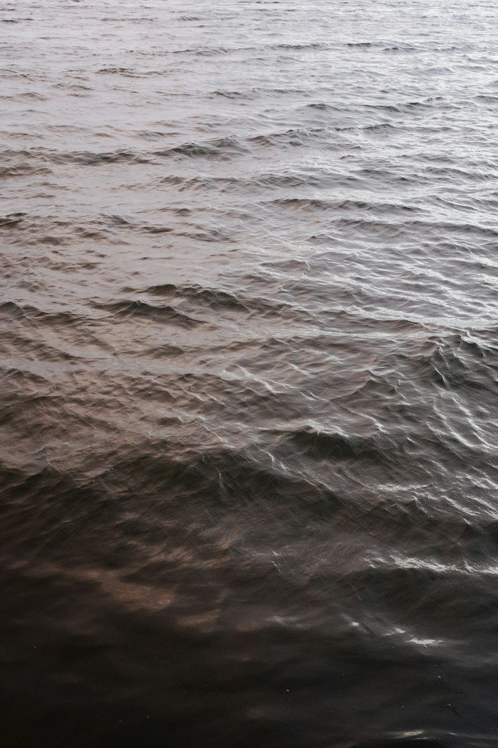 a large body of water with a boat in the distance