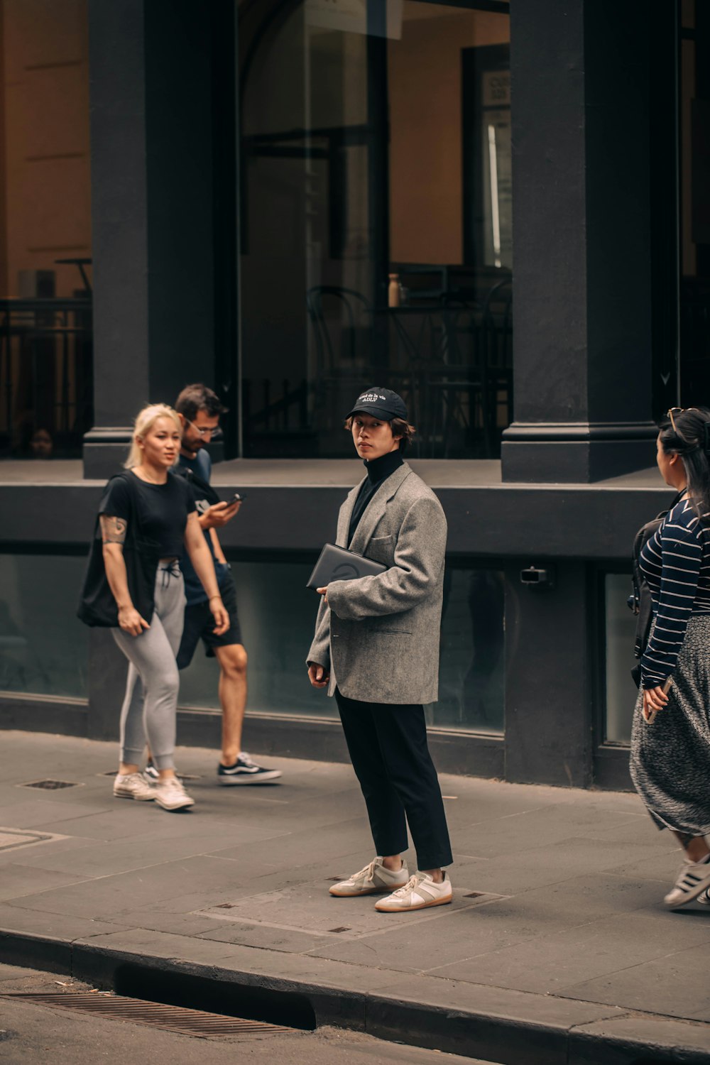 a group of people standing on a sidewalk