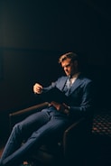 a man in a suit sitting in a chair