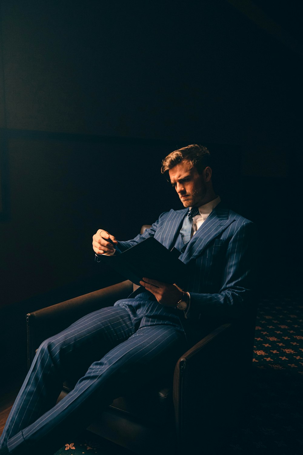 a man in a suit sitting in a chair