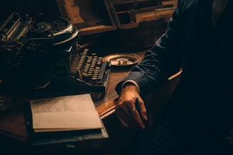 a man sitting at a desk with an old typewriter