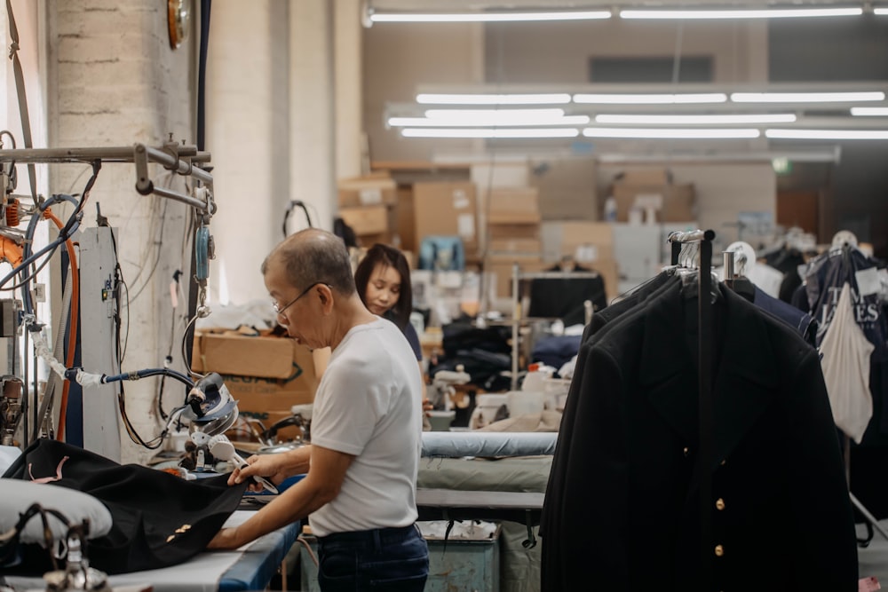 Un hombre trabajando en una prenda de vestir en una fábrica