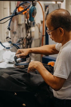 a man in a white shirt working on a piece of luggage