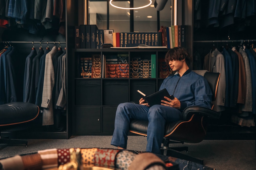 a man sitting in a chair reading a book