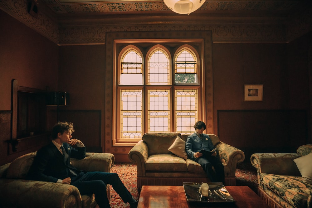 two men sitting on couches in a living room