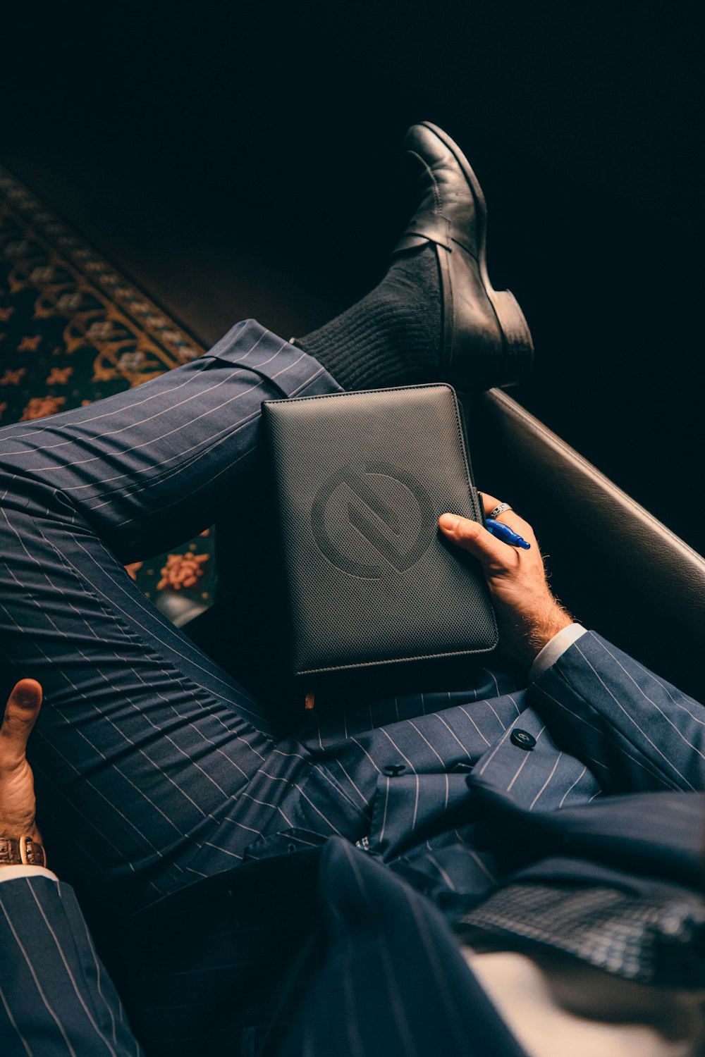a man in a suit is holding a laptop