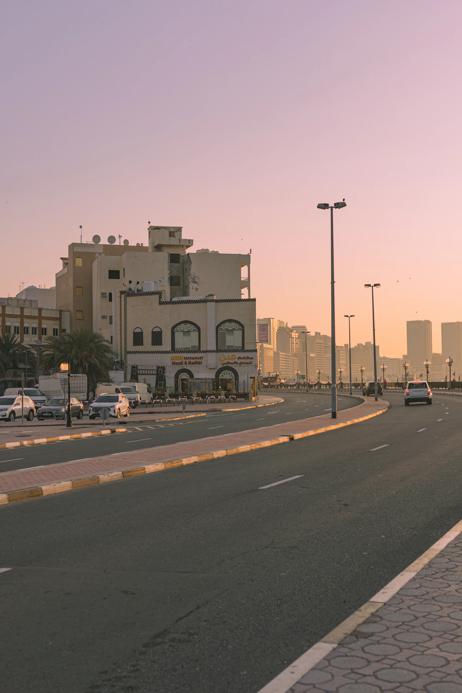 Cars parked along a Dubai street lined with low-rise shopfronts