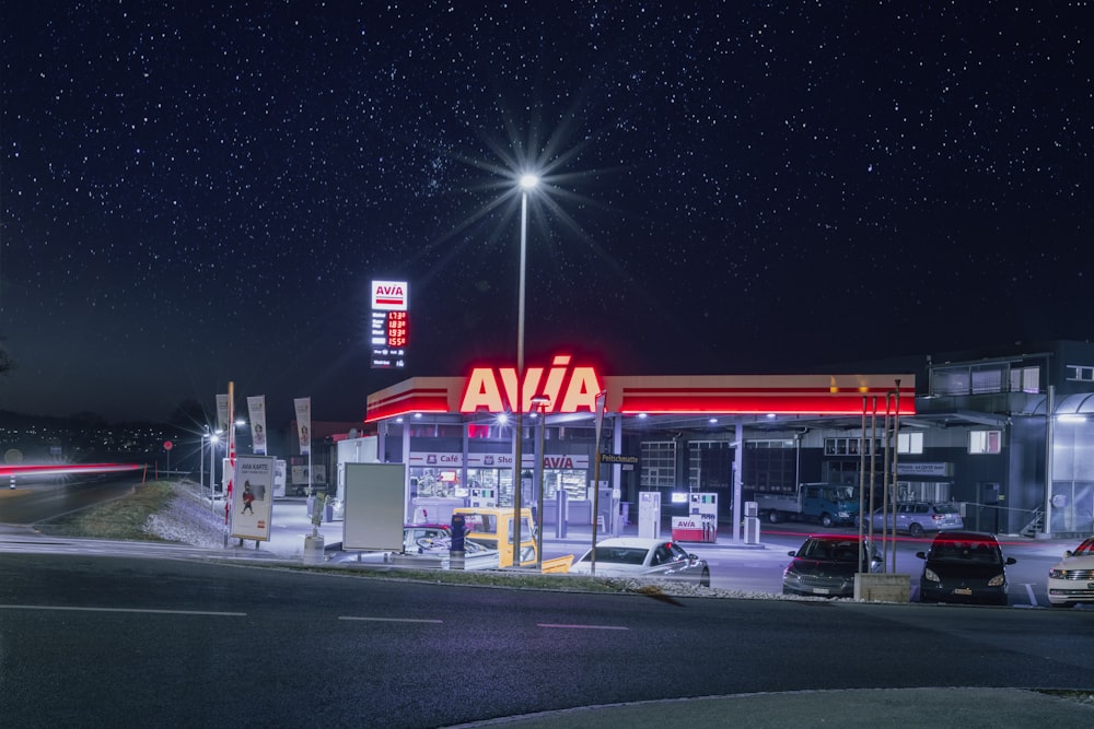 a gas station lit up at night with stars in the sky