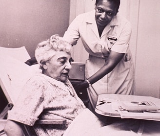 a woman in a hospital bed being assisted by a nurse