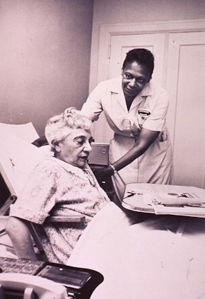 a woman in a hospital bed being assisted by a nurse