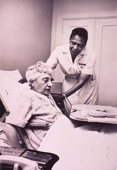a woman in a hospital bed being assisted by a nurse