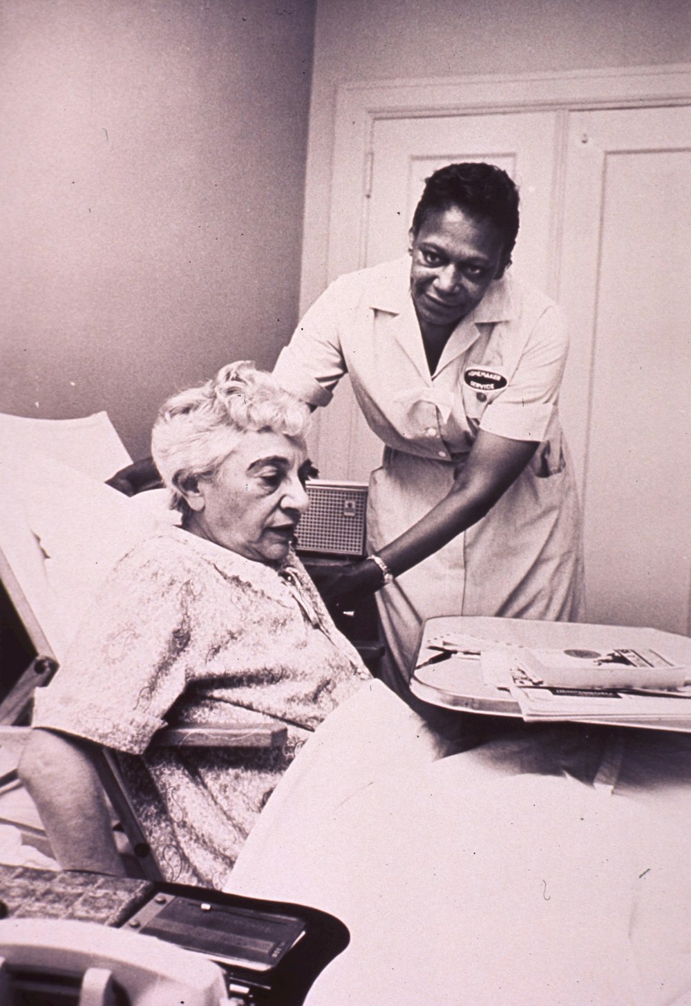 a woman in a hospital bed being assisted by a nurse