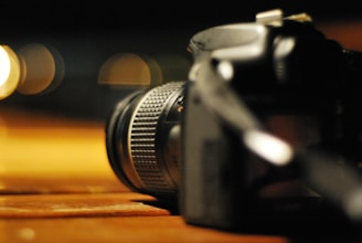 A camera lens focused with a soft bokeh background of warm lights.