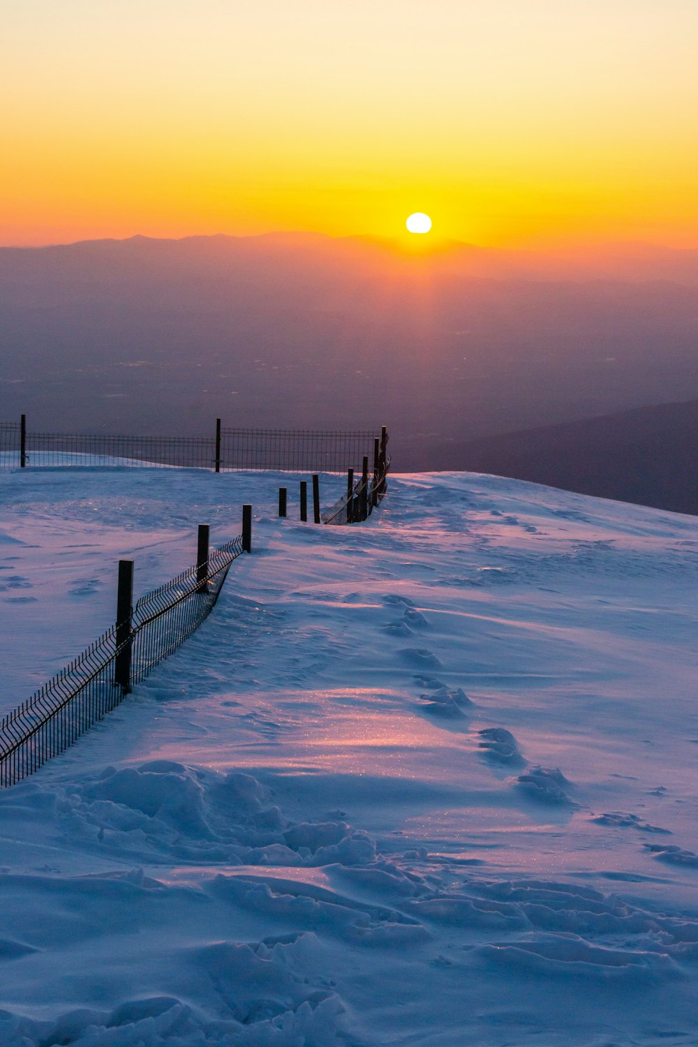 El sol se está poniendo sobre una colina nevada