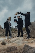 a group of people standing on top of a rocky hillside