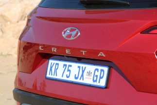 A red Hyundai Creta with prominent branding on its rear, including a visible license plate from Gauteng, South Africa. The vehicle's design features sharp lines and a modern aesthetic, with a shiny surface reflecting natural light.