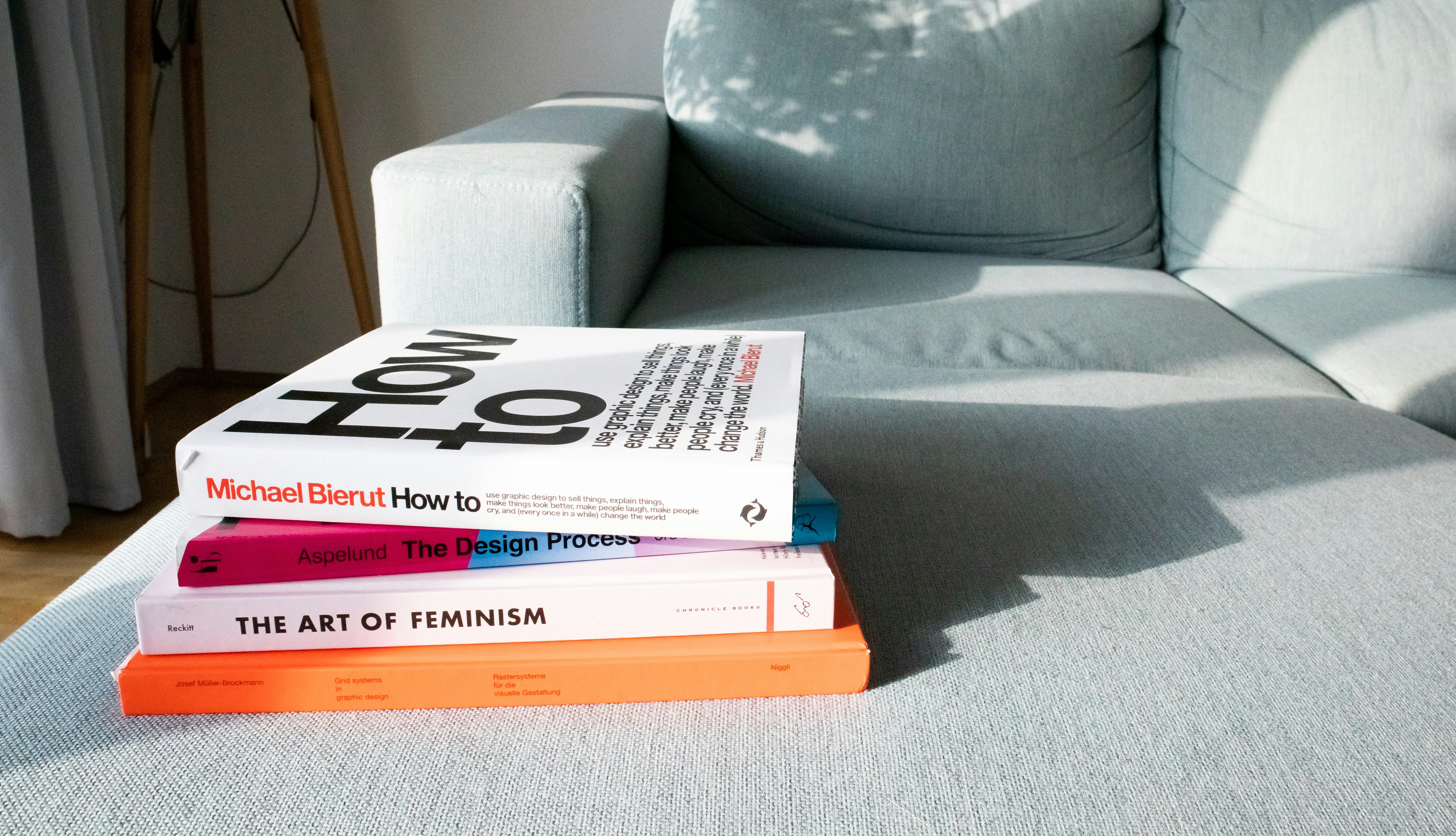 a stack of books sitting on top of a blue couch