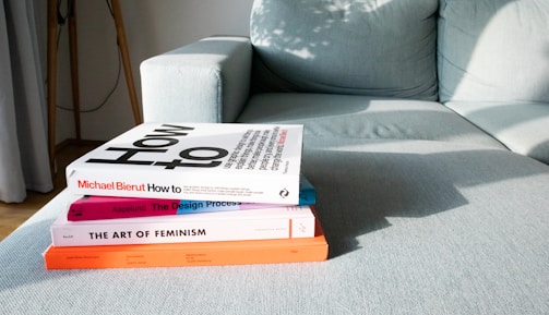 A stack of Above the Sun Books resting on a windowsill with golden afternoon light streaming in.