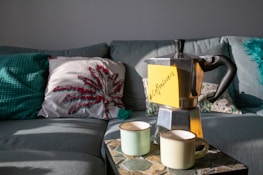 A cozy living room setup featuring coffee-themed decorations and soft cushions.