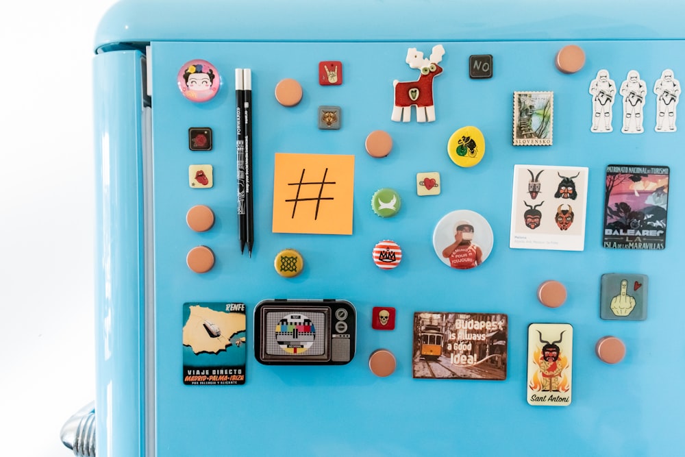 a blue refrigerator with magnets and pictures on it