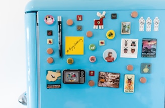 A cozy kitchen fridge adorned with soft pastel square photo magnets featuring family and pet pictures.