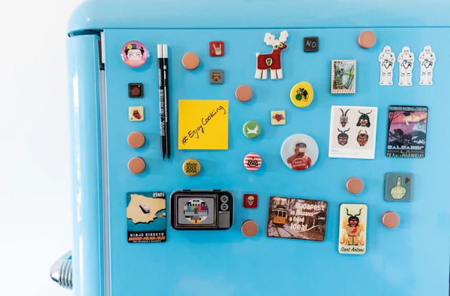 Colorful magnets featuring playful designs arranged on a fridge door.