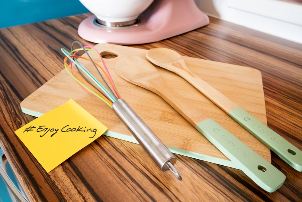 a wooden cutting board topped with kitchen utensils