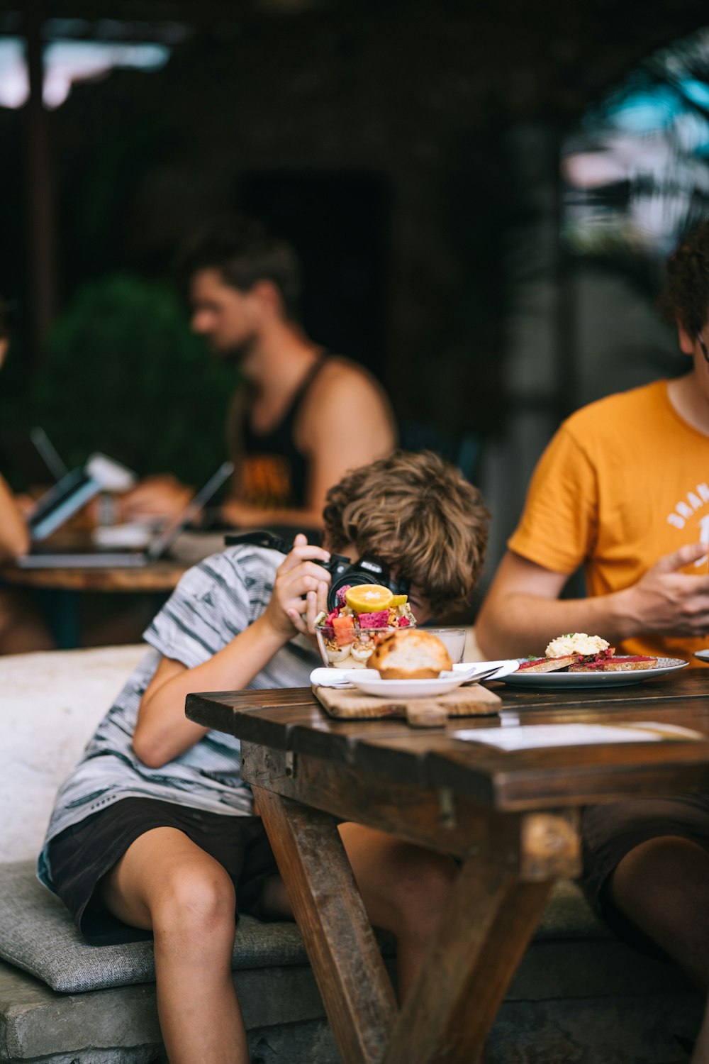 a group of people sitting around a wooden table