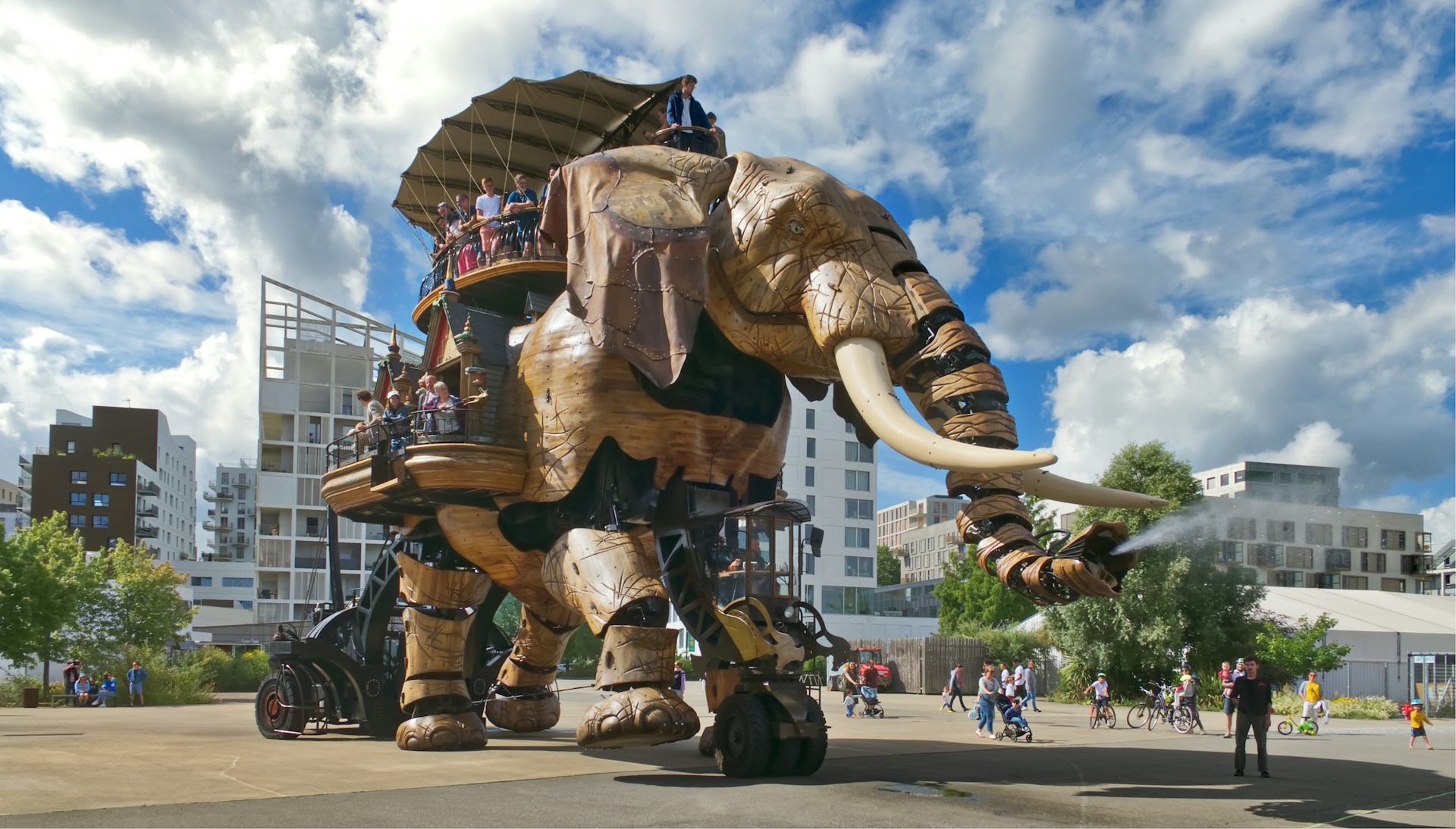 a giant mechanical elephant with people riding on it's back